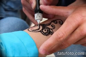 Фото тату: черная татуировка хной на запястье с изображением сложного узора. Традиционное искусство мехенди.