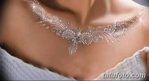 Фото тату: изящный узор, имитирующий кружевное ожерелье на ключицах. Красивый рисунок татуировки для вдохновения.