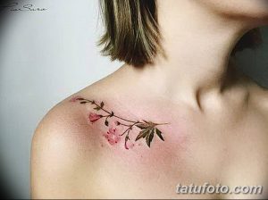 Фото тату: акварельный рисунок ветки с розовыми бутонами на женском плече. Нежные пастельные тона и легкие мазки создают воздушный образ.