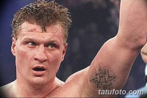 Фото тату кельтского узла на бицепсе мужчины, бойца MMA, с небольшими повреждениями на лице после боя.