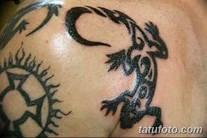 Фото тату игуаны в стиле графика на груди, выполненное черными линиями и узорами. Оригинальный рисунок татуировки.