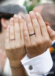 Фото парных тату на пальцах: две тонкие черные линии, обхватывающие безымянные пальцы. Минималистичный рисунок татуировки, символизирующий союз.