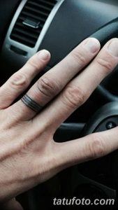 Фото тату на пальце: черная геометрическая полоса, обхватывающая палец. Минималистичный рисунок татуировки, выполненный в графическом стиле.