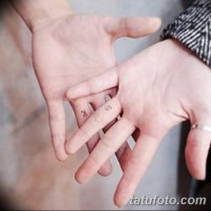 Фото тату на пальцах: два символа, похожие на китайские иероглифы, выполненные в черном цвете. Изящный рисунок татуировки для пары.