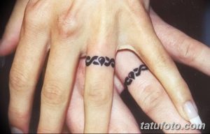 Фото парных татуировок на безымянных пальцах. Черный кельтский узор, выполненный в минималистичном стиле, символизирует вечную любовь и связь между двумя людьми.