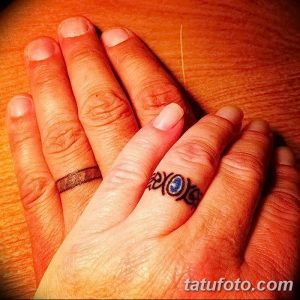 Фото тату с надписью 'XOXO' на пальцах двух людей, символизирующей любовь и нежность. Черно-белый рисунок татуировки.