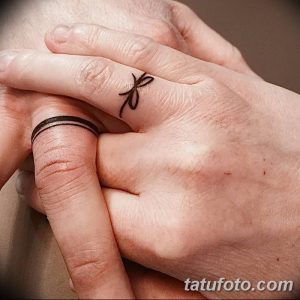 Фото парных татуировок на пальцах. На одном пальце изображена небольшая бабочка, на другом - тонкая черная линия.