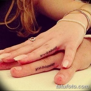 Фото тату: Две руки с парными татуировками на пальцах: римские цифры 'XIV-II-MMXII' и 'XIV-II-MMXII'. Символичный рисунок татуировки.