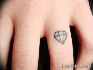 Фото миниатюрной татуировки в виде бриллианта на пальце. Простой и элегантный дизайн.