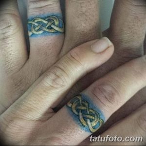 Фото тату: Две руки с татуировками в виде кельтских узлов на пальцах. Татуировки выполнены в сине-зеленых тонах с золотыми акцентами.