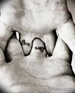 Фото тату на пальцах: парные татуировки с надписью "Love", разделенной между двумя пальцами. Черный цвет, простой шрифт.