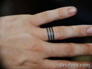 Фото тату на пальце: три тонкие черные линии, расположенные горизонтально. Минималистичный дизайн, простой эскиз татуировки.