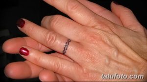 Фото тату: тонкая татуировка в виде браслета на пальце, выполненная в минималистичном стиле.
