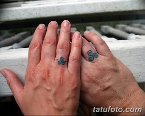 Фото парных тату с изображением кельтских трикветров на пальцах. Небольшие, но символичные рисунки татуировки в бирюзовых тонах. Идея для тату для пары.