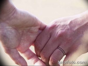 Фото тату: тонкая черная линия, имитирующая кольцо, на безымянном пальце руки. Минималистичный и элегантный дизайн.
