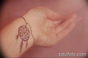 Фото тату ловца снов в минималистичном стиле, расположенное на запястье. Тонкие линии и простой дизайн создают элегантный образ.