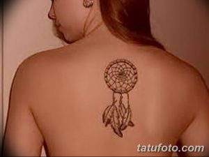 Фото минималистичной татуировки с ловцом снов и перьями на спине. Небольшой и изящный рисунок татуировки для девушек, выполненный в черно-серых тонах.
