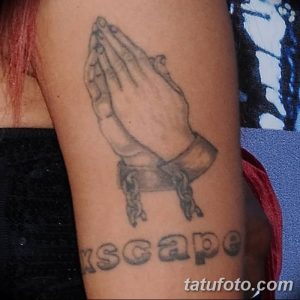 Фото тату молящихся рук с надписью 'ESCAPE'. Рисунок выполнен в черно-серых тонах с использованием четких линий и теней.