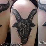 Фото татуировки головы козла с пентаграммой на лбу. Черно-белый рисунок с детализированной проработкой шерсти и рогов. Символ сатанизма и оккультизма.