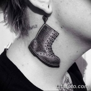Фото тату на шее: ботинок Dr. Martens, выполненный в черно-серых тонах. Реалистичный стиль, детальная прорисовка, необычное расположение.