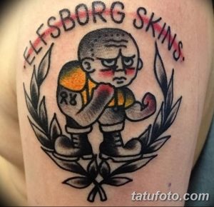 Фото тату на руке: боксер в стиле олдскул с надписью "Elfsborg Skins". Яркий и детализированный рисунок татуировки.