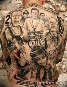 Фото тату с портретами и надписями в стиле skinhead на спине мужчины. Черно-серый рисунок татуировки с множеством деталей.