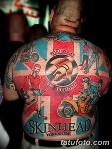 Яркая татуировка флага Великобритании на спине мужчины в стиле Skinhead. Изображены символы и элементы, характерные для этой субкультуры.
