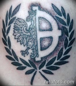 Фото тату на плече с изображением орла, обвивающего букву "B", в лавровом венке. Черно-серый рисунок татуировки в стиле графика.