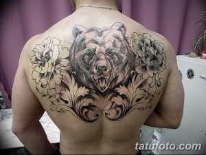 Фото реалистичной татуировки медведя и роз на спине, выполненной в черно-серых тонах с высокой детализацией. Мощный и красивый рисунок татуировки.