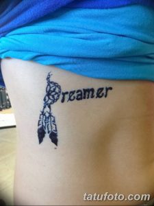 Фото тату мехенди на боку. Изображение ловца снов и надписи 'Dreamer', выполненное в технике росписи хной.