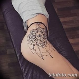 Фото тату мехенди на бедре, выполненное в черных тонах. Детализированный узор с геометрическими фигурами и цветочными мотивами.