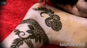 Фото тату мехенди на лодыжке, в процессе нанесения мастером. Запечатлен момент создания изящного узора с использованием хны.