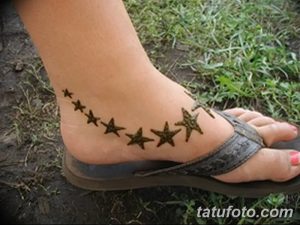 Фото тату мехенди в виде цепочки звезд на лодыжке. Минималистичный и стильный дизайн.
