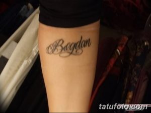 Фото тату: имя 'Bogdan', написанное красивым шрифтом на предплечье, выполненное черными чернилами.