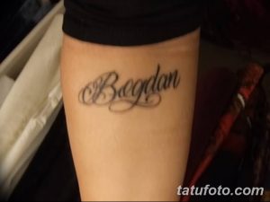Фото тату: надпись "Bogdan" на запястье, выполненная черными чернилами. Татуировка выглядит стильно и лаконично.