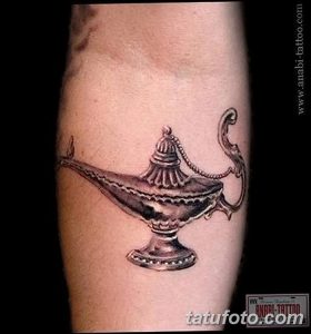 Фото тату на руке с изображением лампы в черно-белом стиле. Детализированная проработка и реалистичные тени.