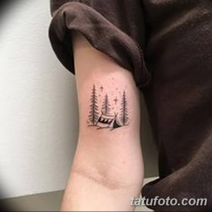 Фото тату на предплечье с изображением палатки между елей под звездным небом. Небольшой и милый рисунок.