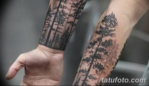 Фото тату: Татуировка леса, охватывающая оба предплечья. Реалистичный рисунок татуировки с изображением нескольких елей, выполненный в черно-серых тонах.