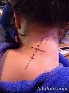 Фото тату: Минималистичная надпись 'Faith' (Вера) с крестом, выполненная тонкой линией на шее девушки. Элегантный и сдержанный дизайн.