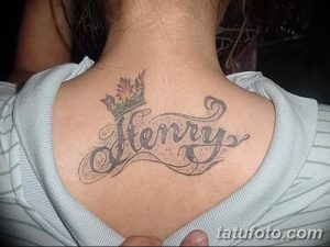 Фото тату с именем 'Henry' и изображением короны, выполненное в серо-черных тонах на спине мужчины. Эскиз татуировки с королевским символизмом.