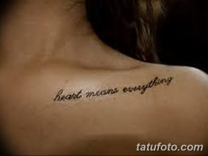 Фото тату: надпись "Heart means everything" красивым шрифтом на спине девушки. Нежный рисунок татуировки с романтическим смыслом.