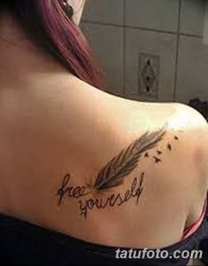 Фото тату на лопатке с изображением пера и надписью "free yourself", выполненное в минималистичном стиле.
