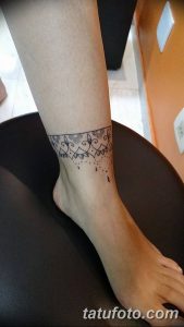 Фото тату мехенди на лодыжке, выполненное в минималистичном стиле. Тонкий браслет с деликатными узорами и капельками создает элегантный образ.