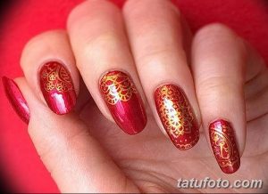Фото маникюра с красным лаком и золотым узором. Изысканное сочетание цветов и узоров создает эффектный и запоминающийся образ.