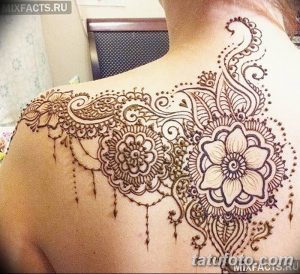 Фото татуировки хной на плече и груди. Сложный восточный узор с цветочными элементами, выполненный коричневой хной. Детализированный и изящный дизайн.
