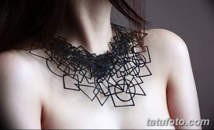 Фото тату: абстрактная геометрическая татуировка, состоящая из черных линий и фигур, расположенная на ключице женщины.