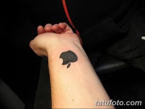 Фото тату на запястье: минималистичное изображение логотипа Apple, выполненное в черном цвете. Простой и лаконичный рисунок татуировки.