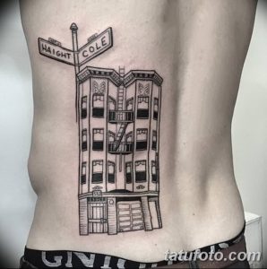 Фото тату с изображением многоэтажного дома и указателя улиц Haight и Cole, выполненного в черном цвете на спине.