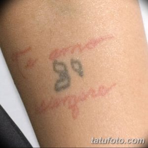 Фото старой, выцветшей татуировки на руке: цифра 39 и надпись 'angeles', выполненные в простом стиле. Изображение демонстрирует пример тату, потерявшего яркость со временем.