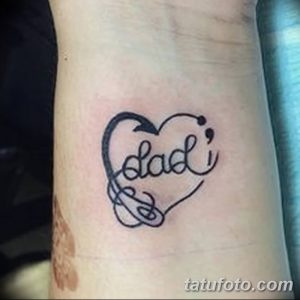 Фото тату небольшого рисунка в форме сердца, внутри которого написано слово "Dad". Татуировка выполнена черными линиями.